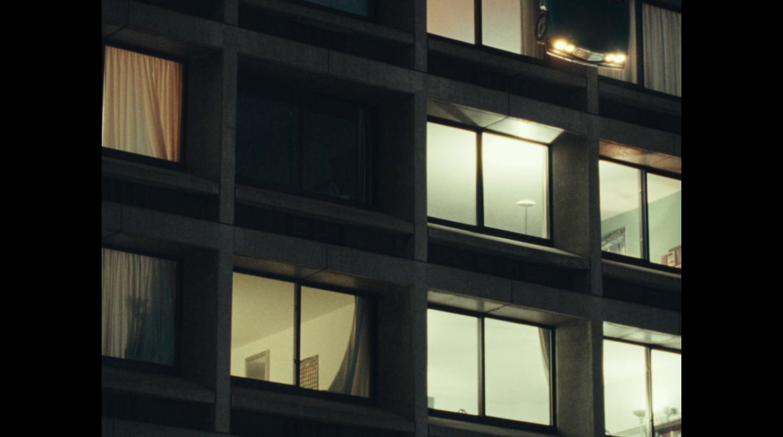 a tall building with lots of windows lit up at night