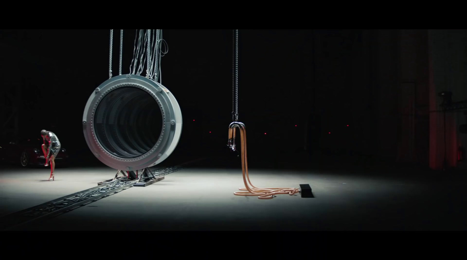 a man standing next to a giant tire in a dark room