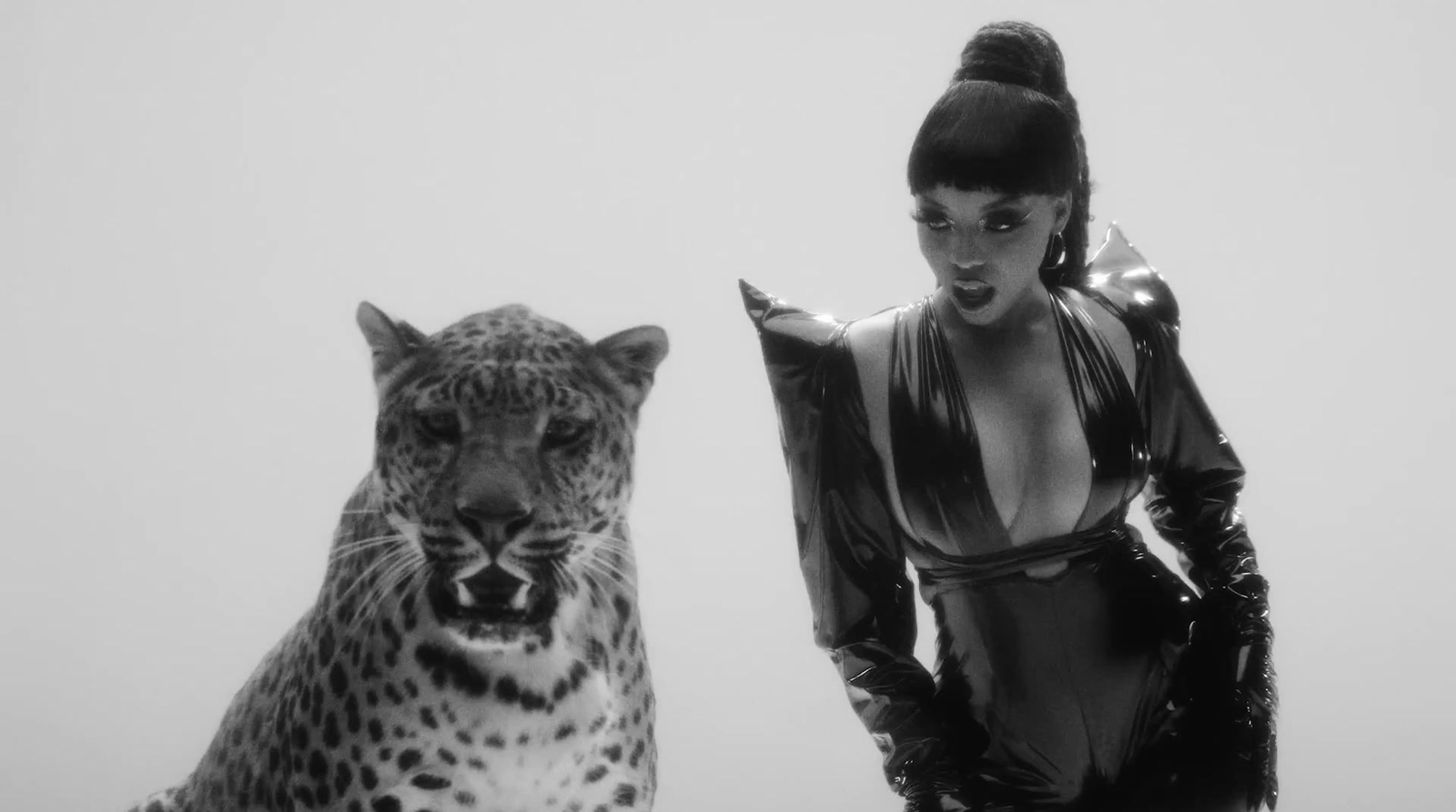 a black and white photo of a woman and a leopard