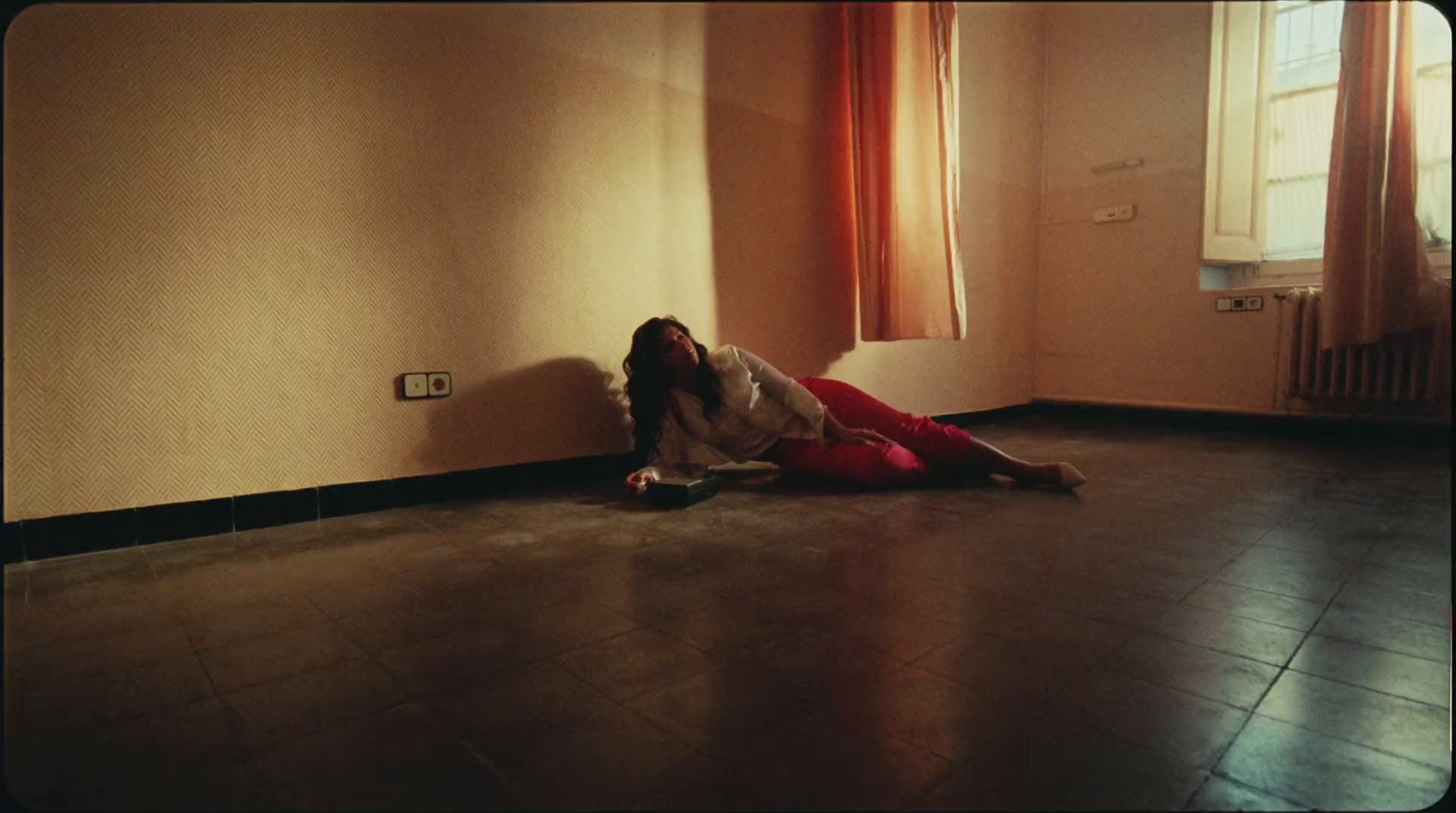 a woman sitting on the floor next to a window