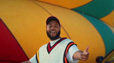 a man giving a thumbs up in front of a large balloon