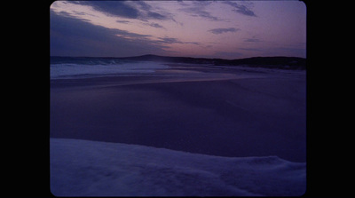 a view of a beach at dusk with a purple sky