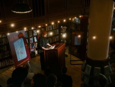 a woman standing at a podium in front of a crowd of people