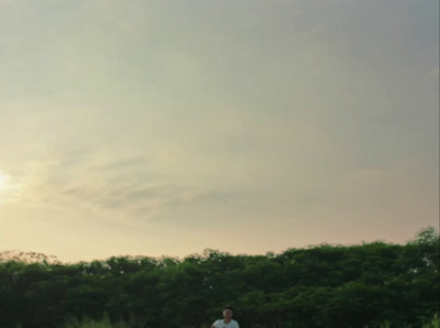 a man standing in a field flying a kite