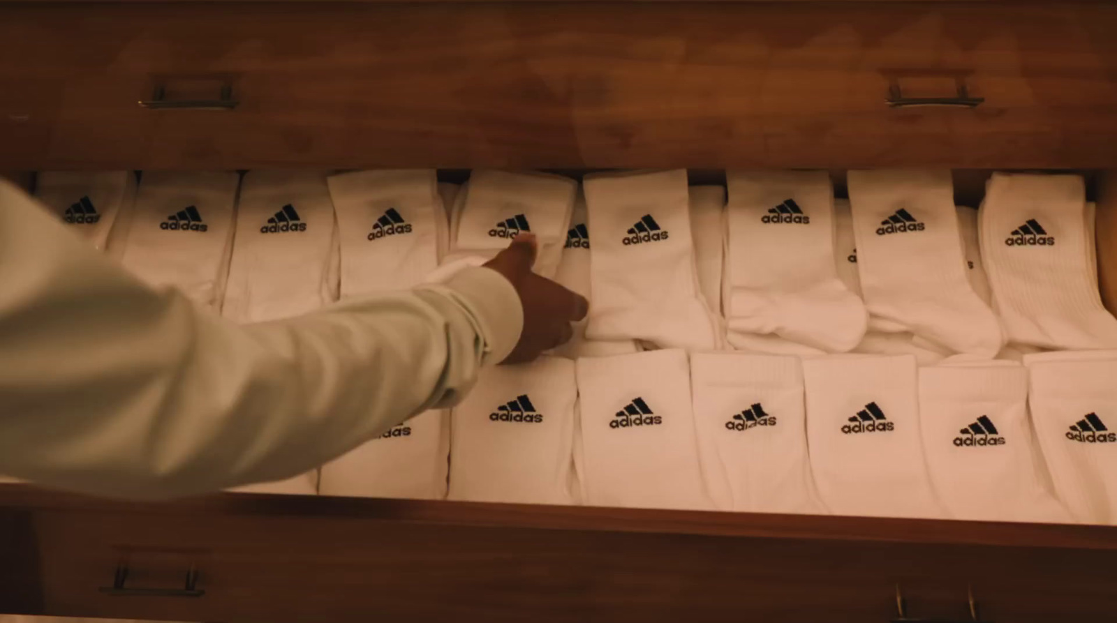 a person pointing at a drawer full of white socks