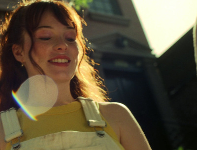 a woman in a yellow dress holding a white frisbee