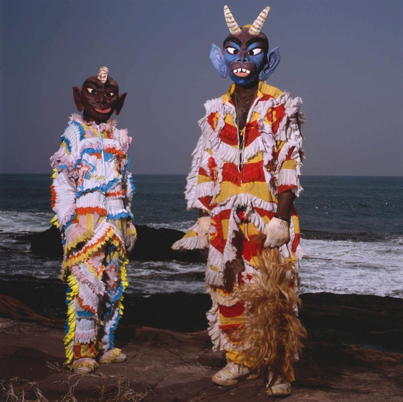 a couple of people standing next to each other near the ocean