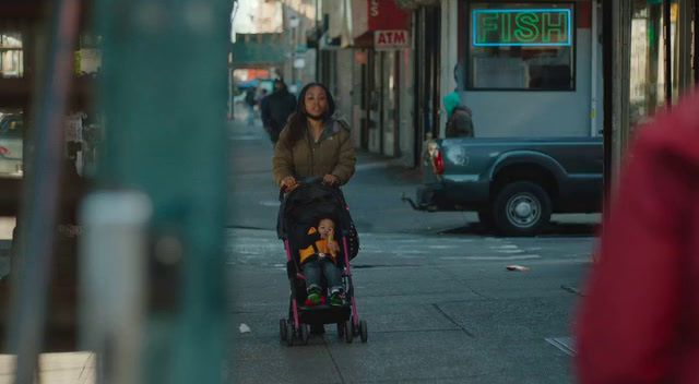 a woman pushing a stroller down a city street