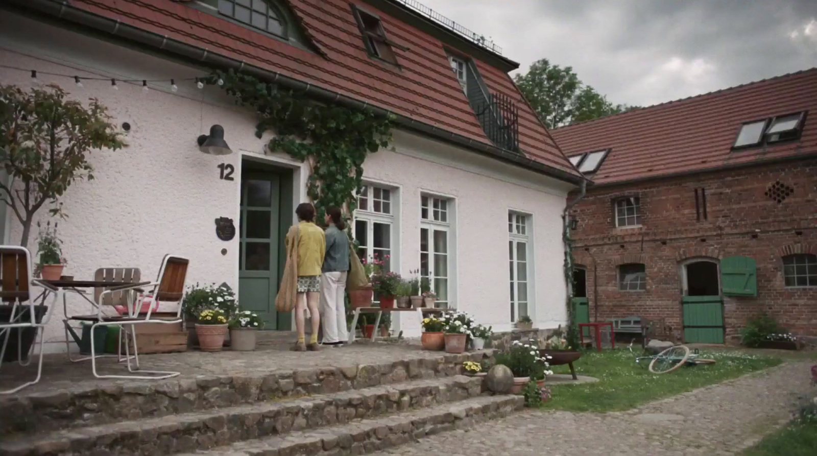 a couple of people that are standing outside of a house