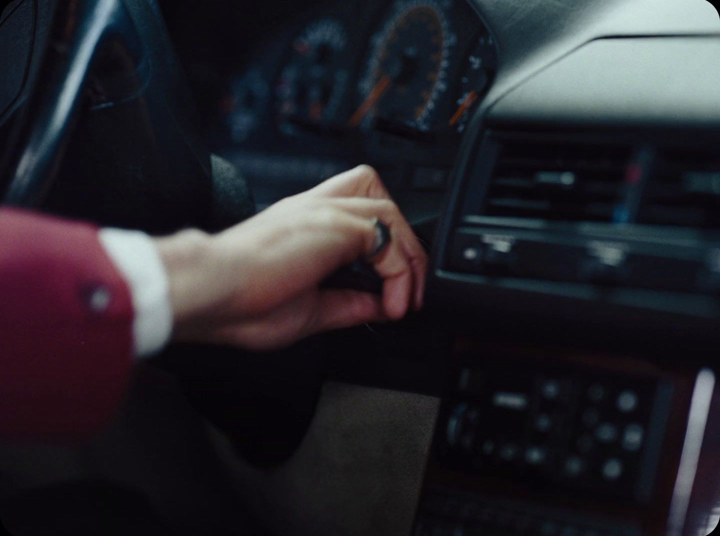 a person is holding the steering wheel of a car