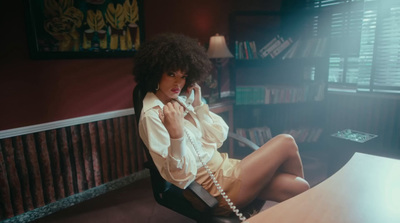 a woman sitting at a desk talking on a phone