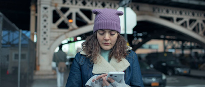 a woman in a purple hat looking at her cell phone