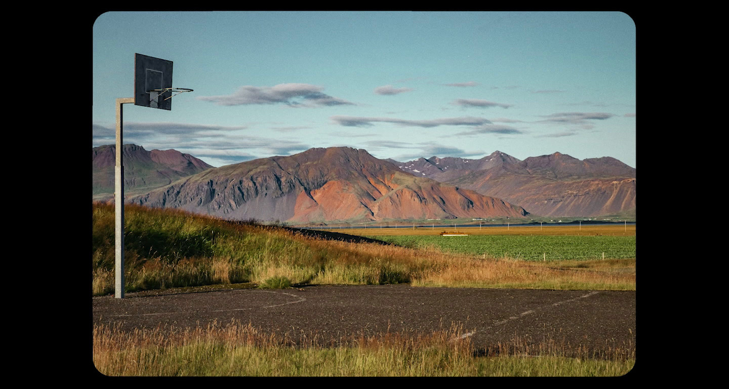 a view of a mountain range with a basketball hoop in the foreground