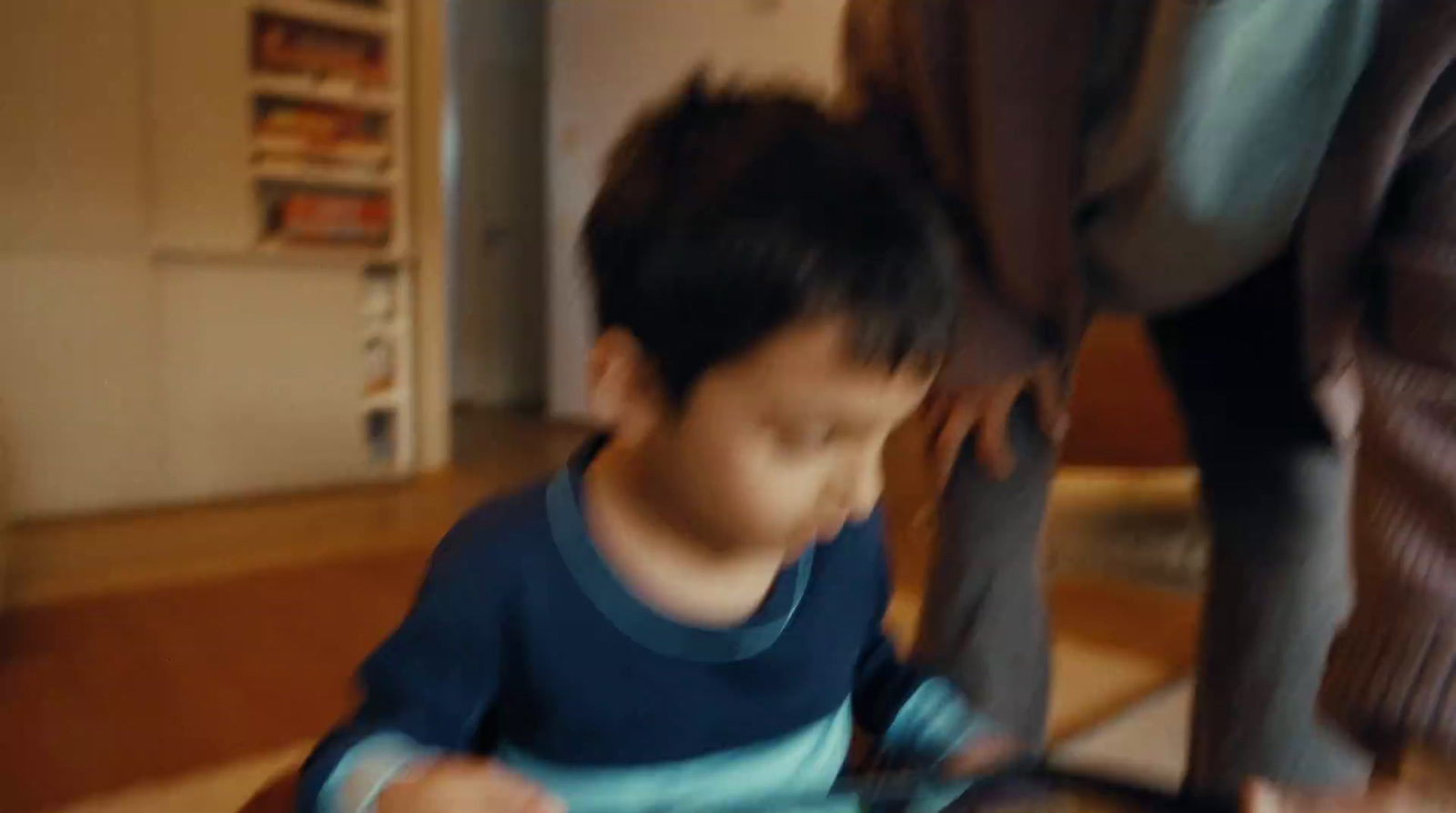 a young boy sitting at a table with a plate of food