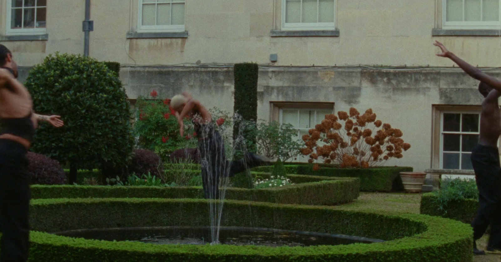 a couple of men standing in front of a fountain