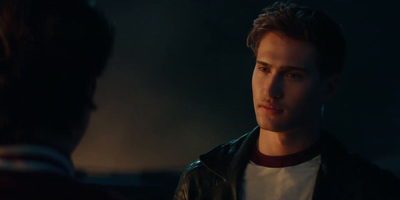 a man in a leather jacket looking at another man