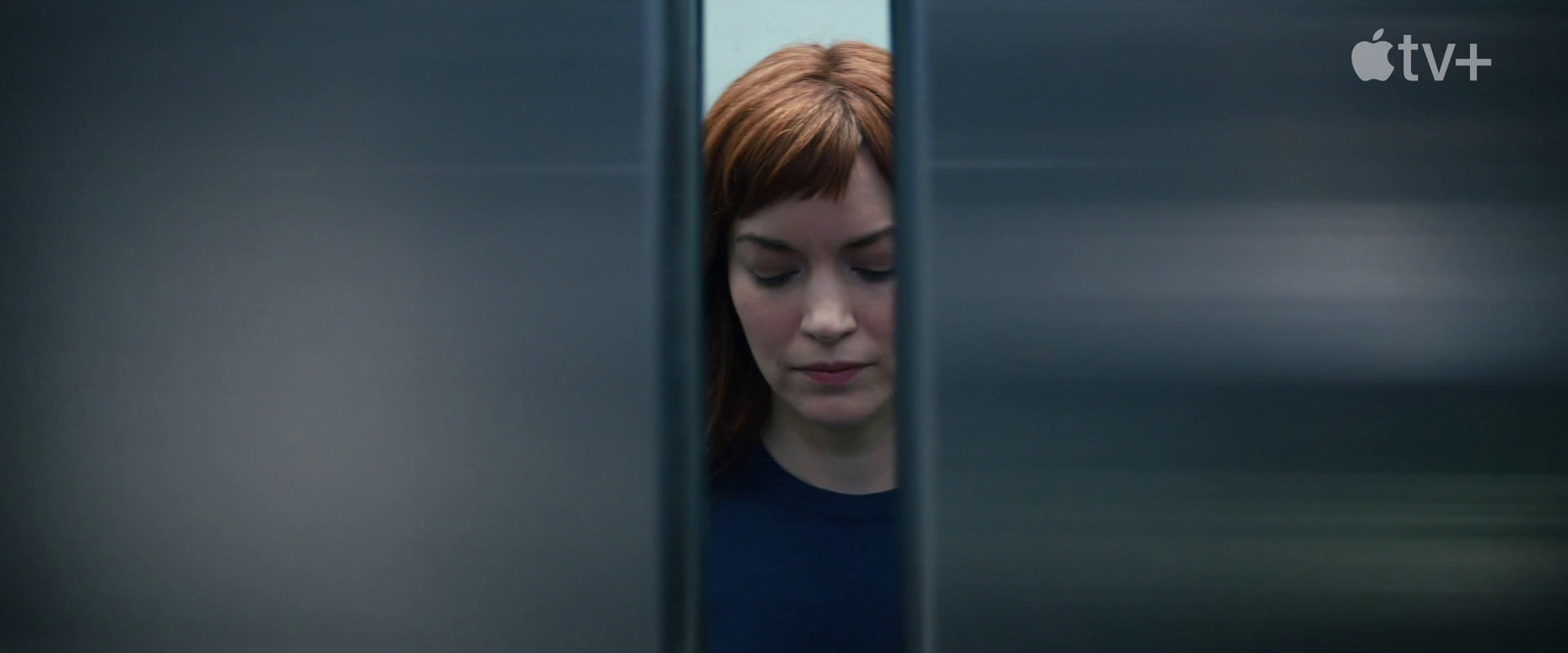 a woman looking through the bars of an elevator