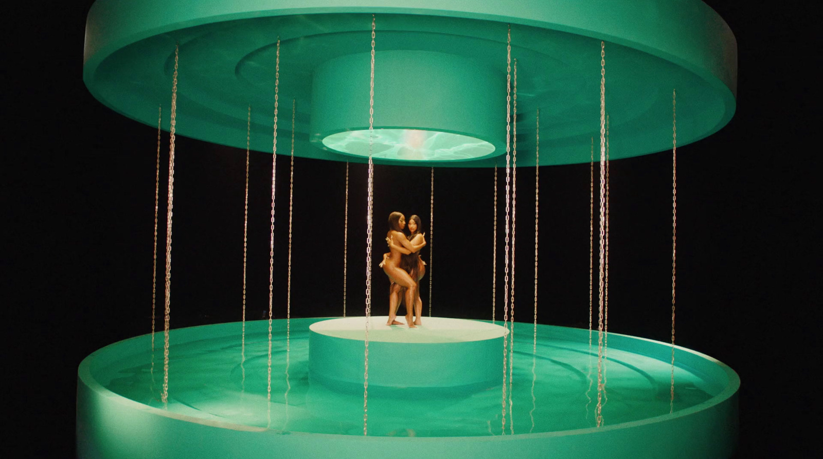 a woman standing on top of a stage with chains hanging from the ceiling