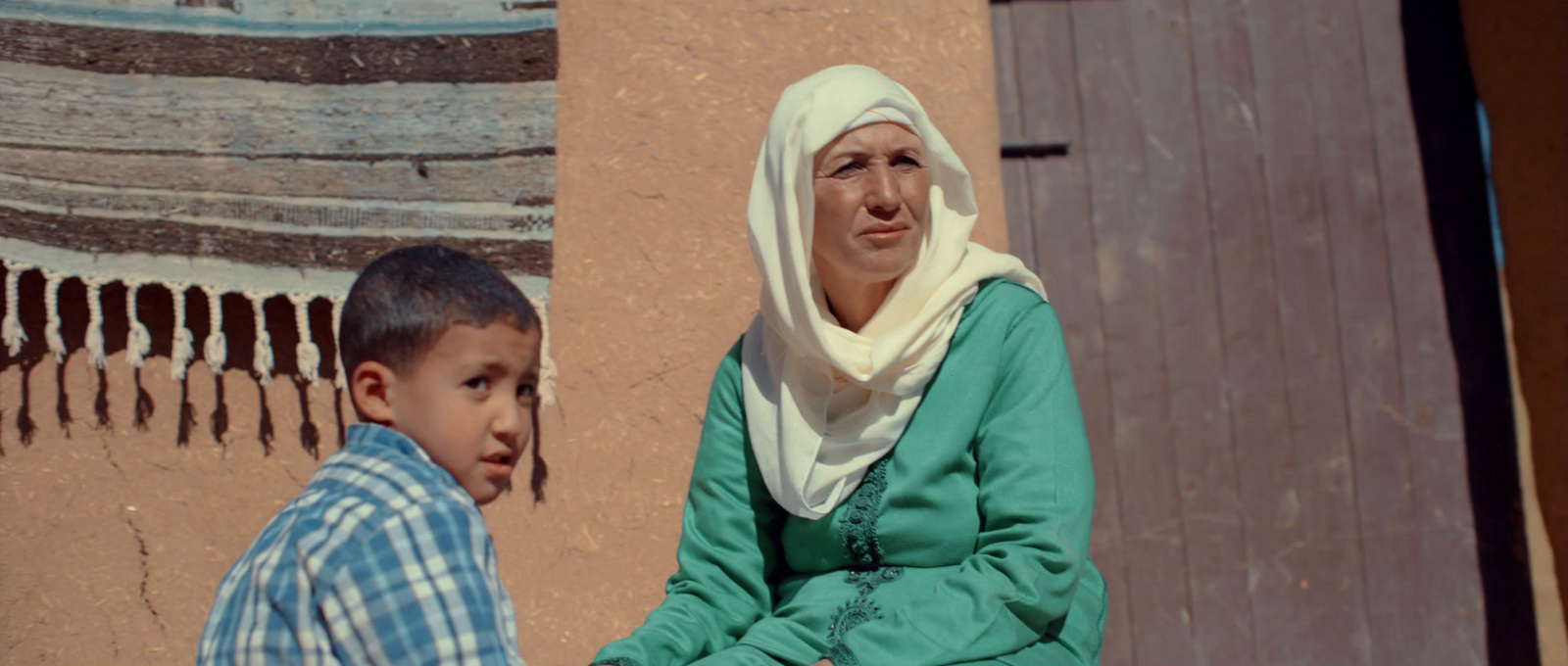 a woman and a boy standing in front of a building