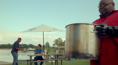 a man in a red shirt is holding a large pot