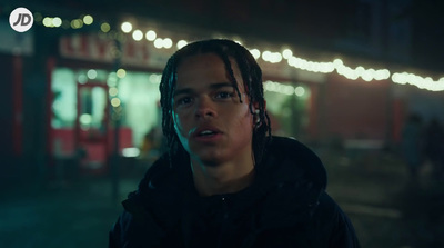 a man with dreadlocks standing in front of a store