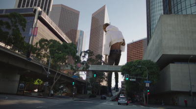 a man riding a skateboard over a bridge over a street