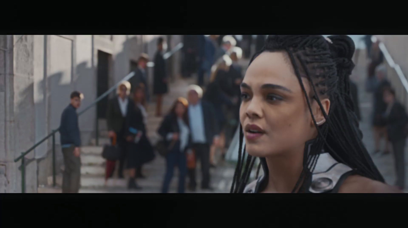 a woman with dreadlocks standing in front of a group of people