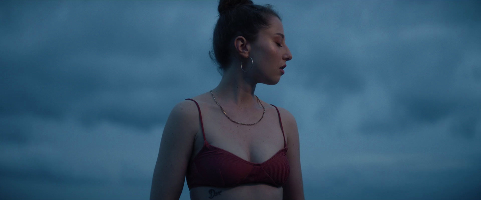 a woman in a red bikini standing in the dark