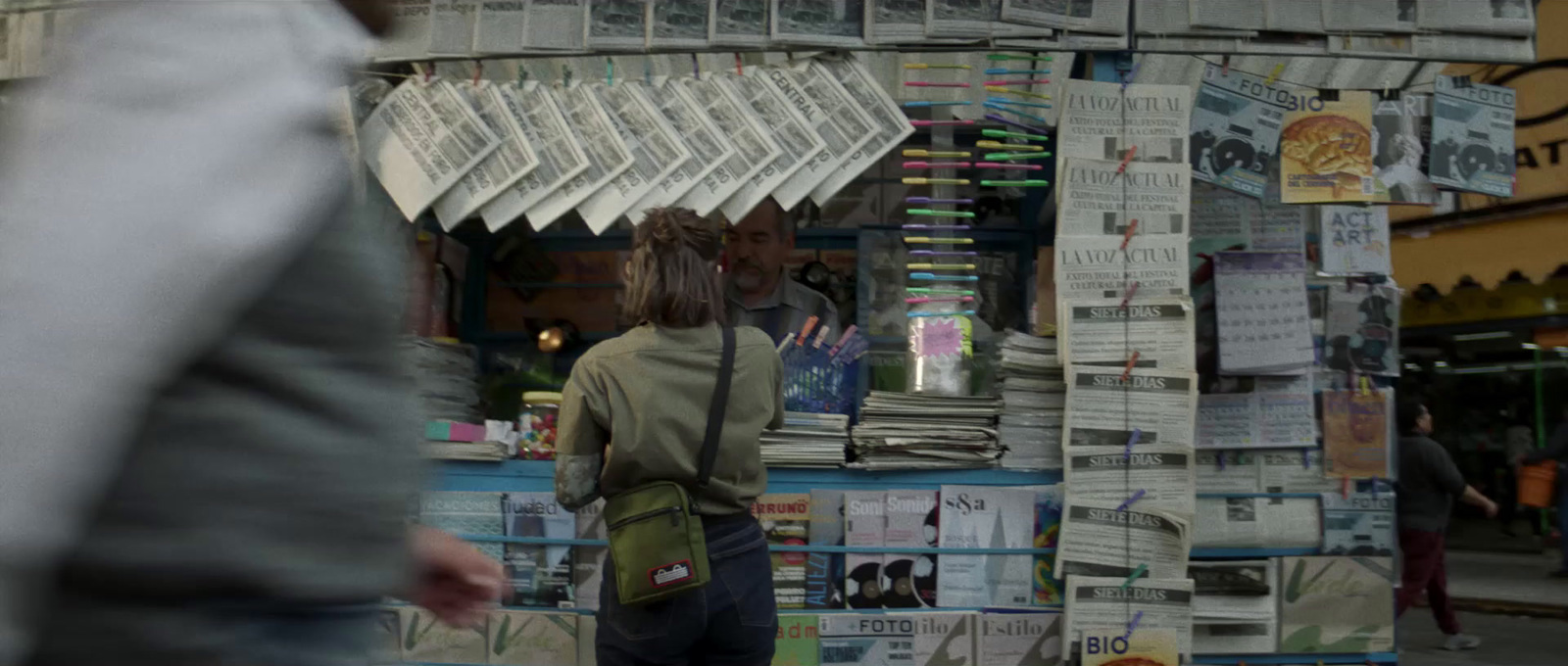 a man standing in front of a newspaper stand