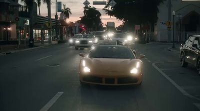 a group of cars driving down a street at night