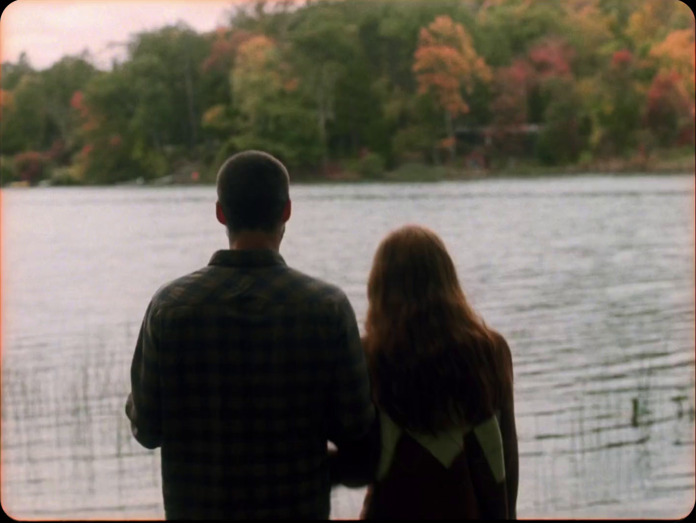 a man and a woman looking out over a lake