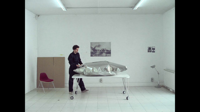 a man standing next to a table with a sculpture on it