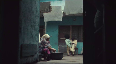 a woman sitting on a bench next to a building