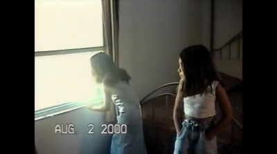 a young girl standing next to a window