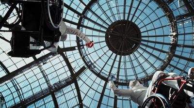 a man in a wheel chair in front of a glass ceiling