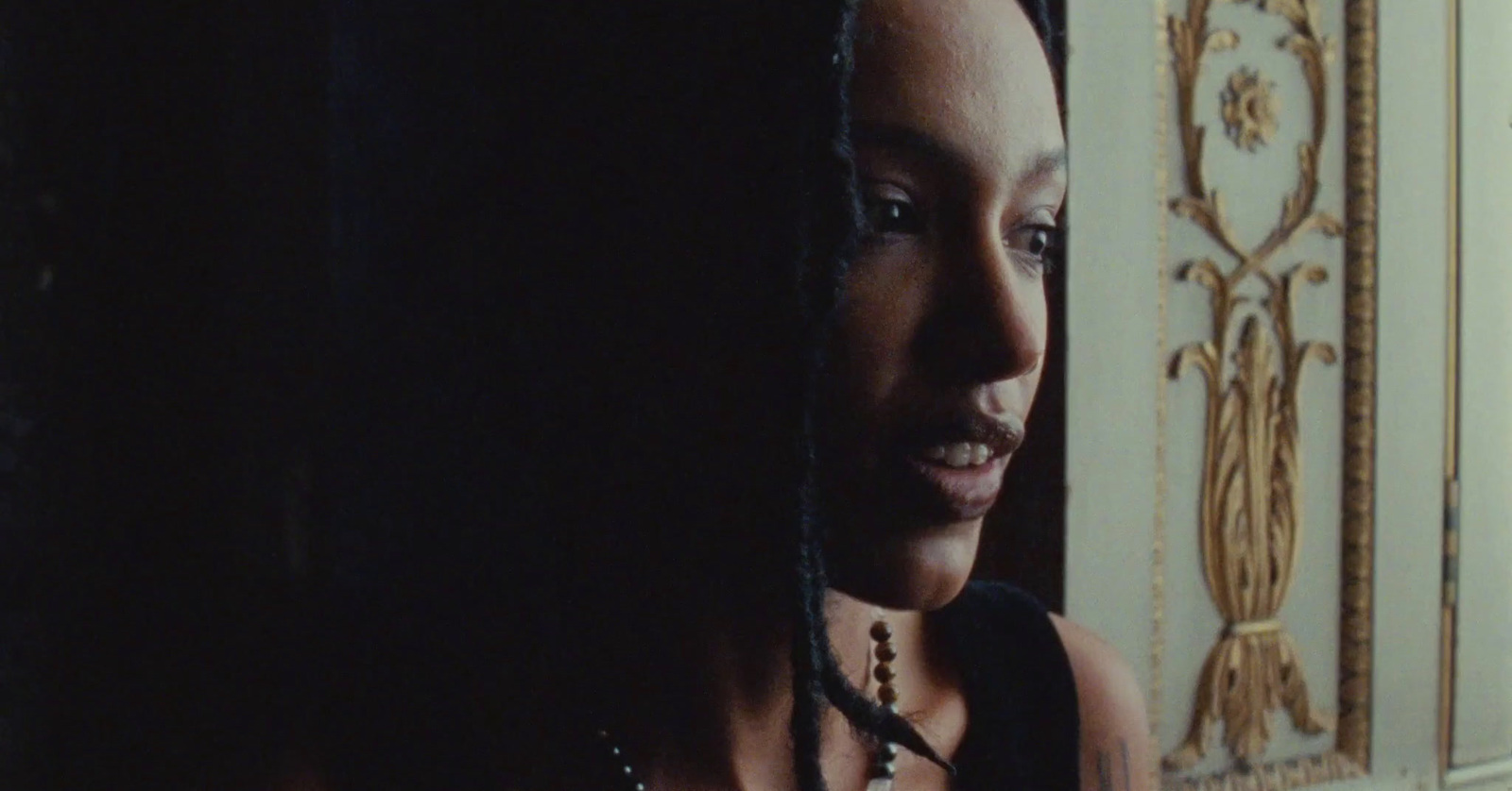 a woman with dreadlocks standing in front of a door