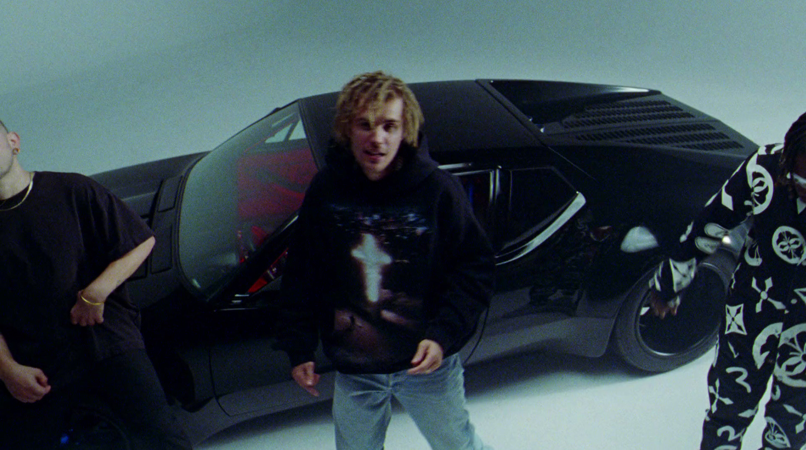 a group of young men standing next to a car