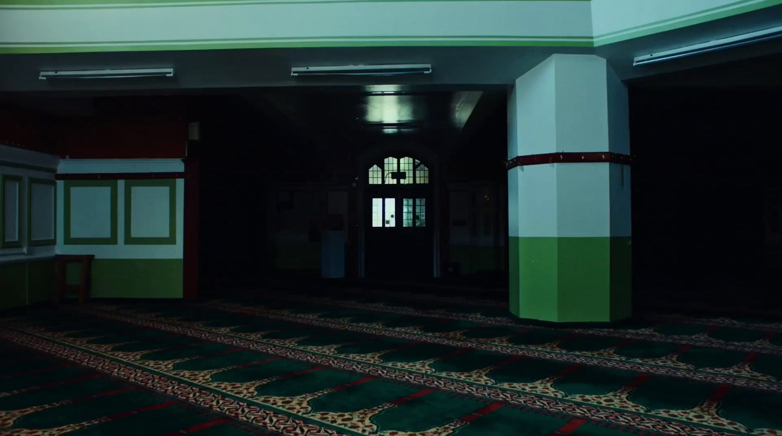 a room with a green and white carpet and a doorway