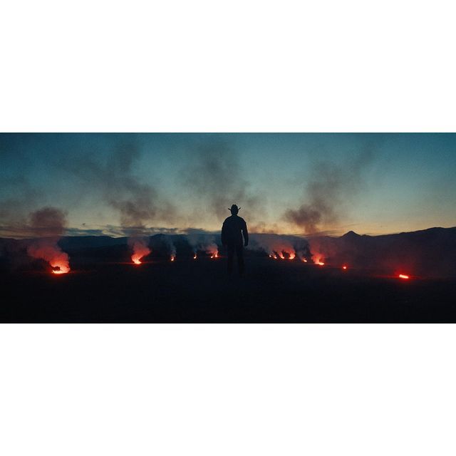 a man standing in front of a field of fire