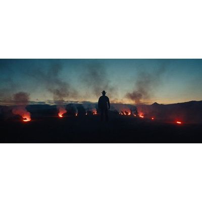 a man standing in front of a field of fire