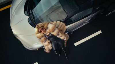 a woman in a fur coat leaning against a car