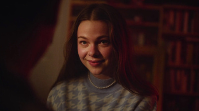 a young woman is smiling in a dark room