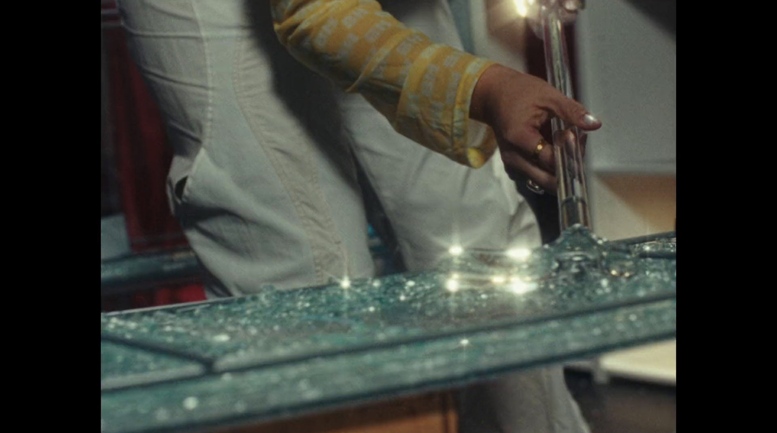 a person standing over a sink with a faucet