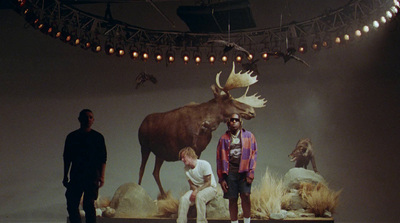 a group of people standing around a fake moose