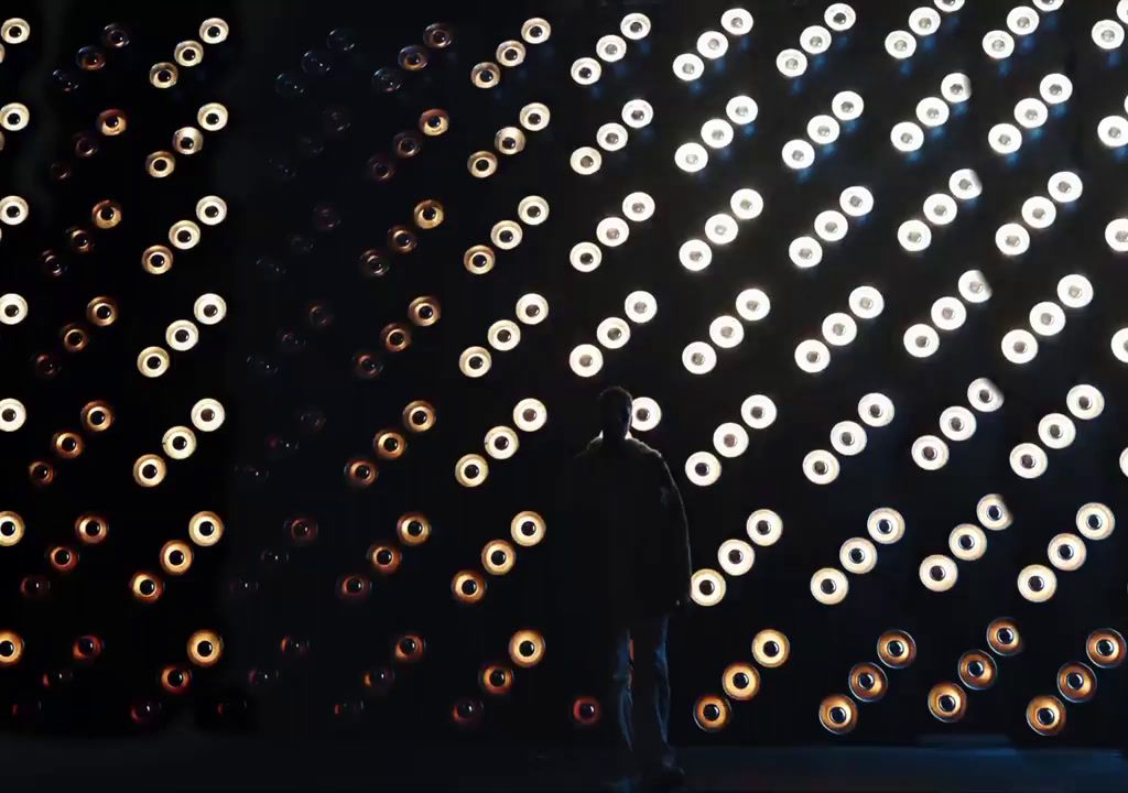 a man standing in front of a wall of lights