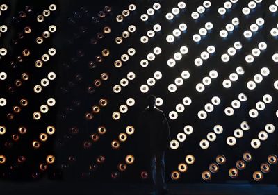 a man standing in front of a wall of lights