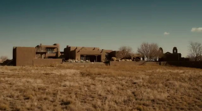 a large brown building sitting on top of a dry grass field