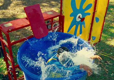 a young boy is playing in a blue bucket