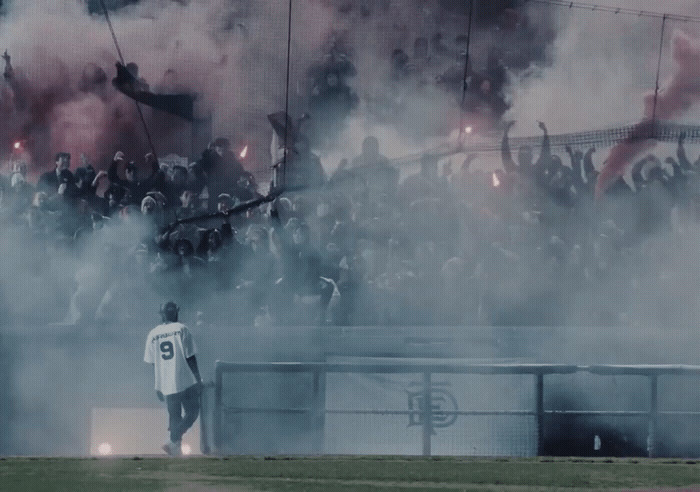 a group of people standing on top of a soccer field