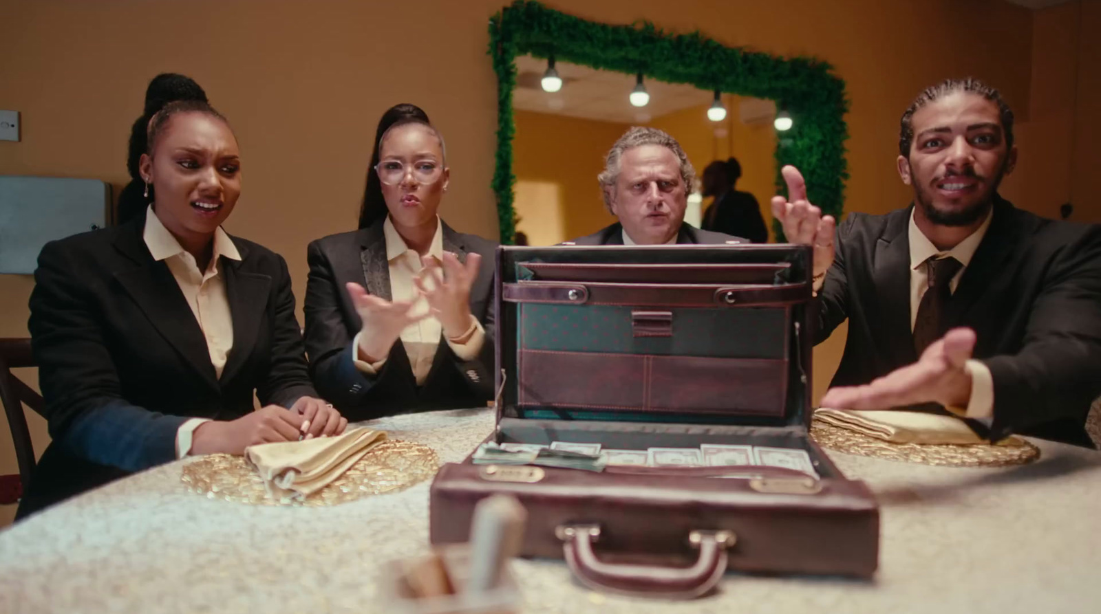 a group of people sitting around a table with a briefcase